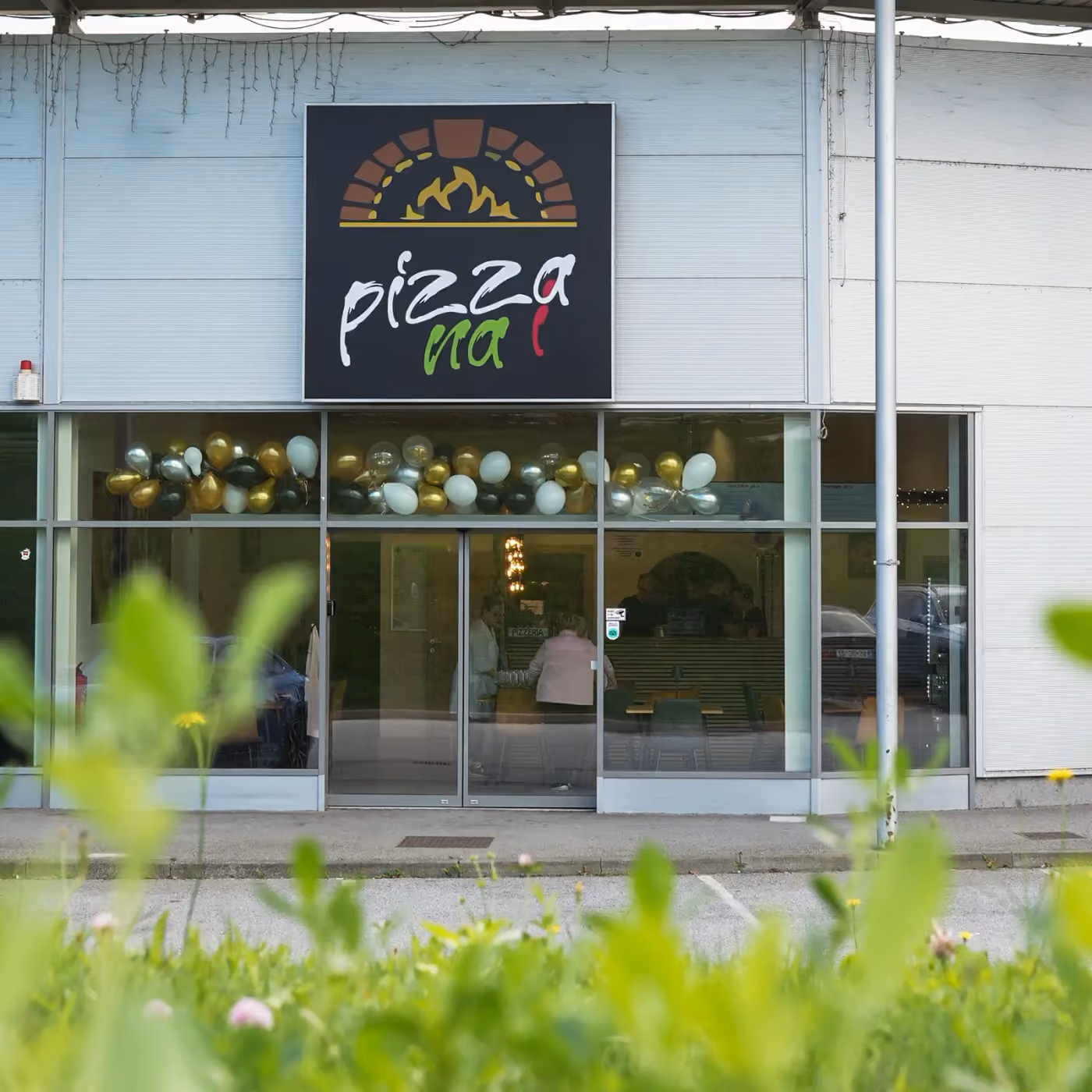 Außenansicht des Lokals in Lenart mit dem Pizza-na-i-Schild