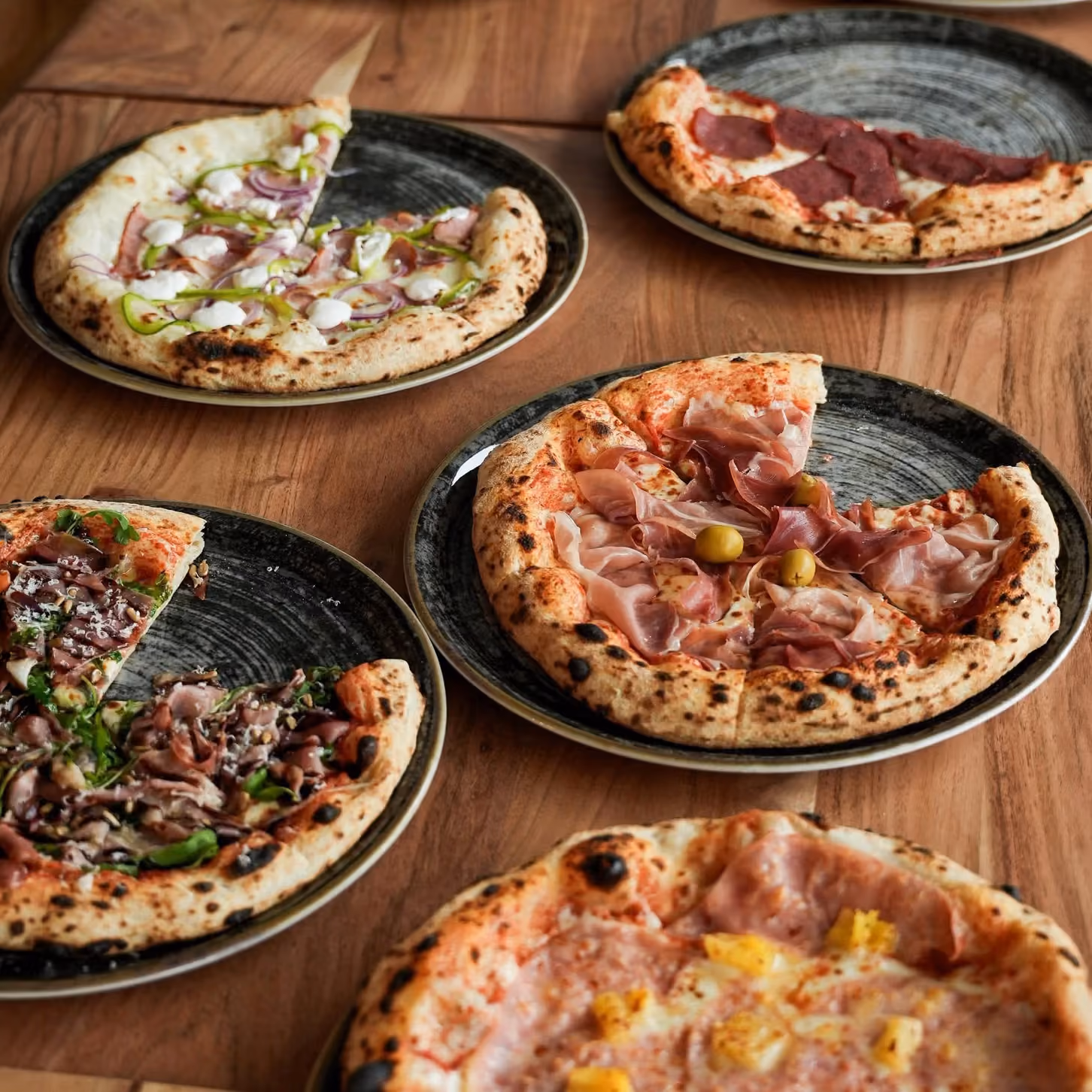 Mehrere frisch gebackene Pizzen auf dem Tisch